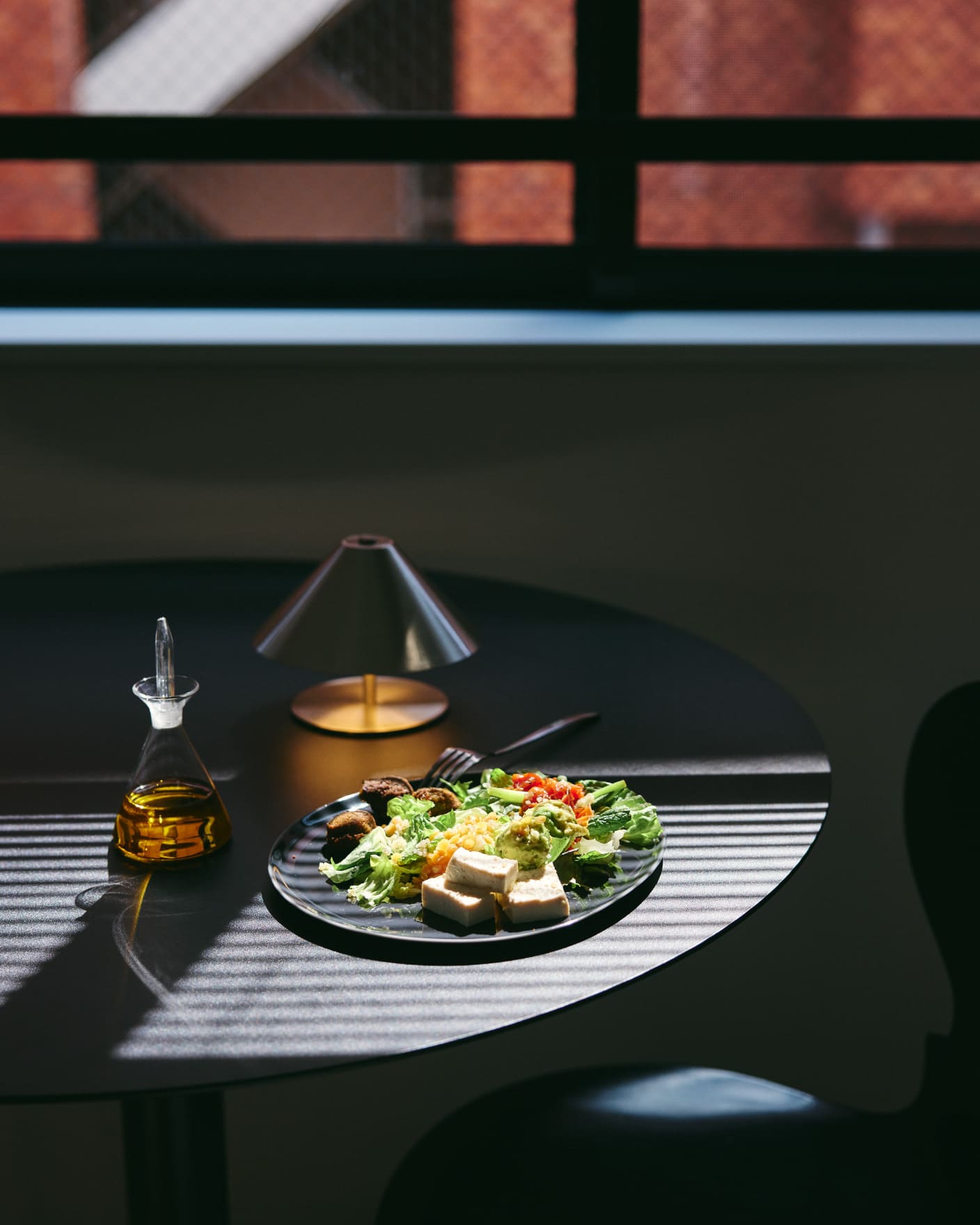 TOLEN SHIROKANE ダイニングテーブルに並べた食事とブラインド越しの光